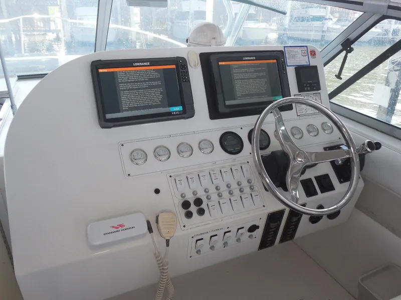 Slide: The Image of 2005 Stamas 370 Express helm with dual displays, gauges, and steering wheel. - 16