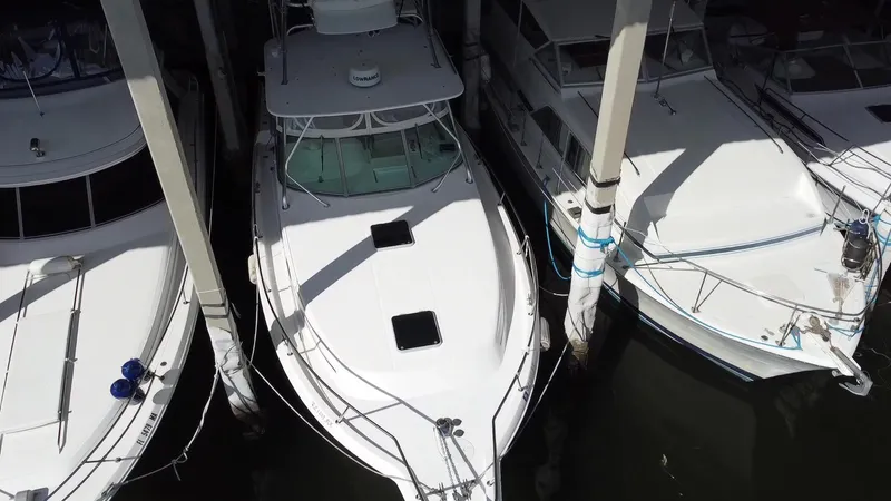 Slide: The Image of 2005 Stamas 370 Express boat docked between two others, aerial view. - 2