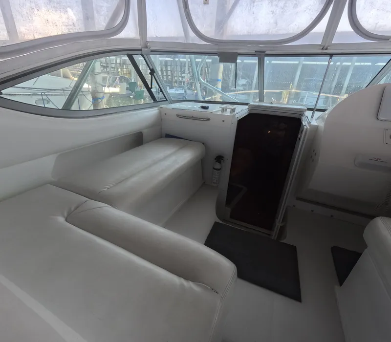Slide: The Image of 2005 Stamas 370 Express boat interior with white seating and helm area. - 23