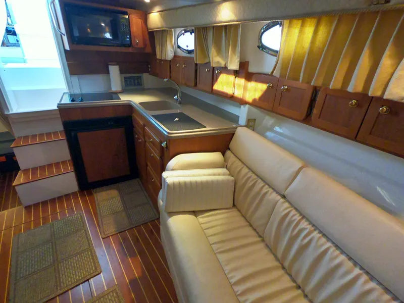Slide: The Image of 2005 Stamas 370 Express interior with kitchenette, beige sofa, and wooden cabinetry. - 35