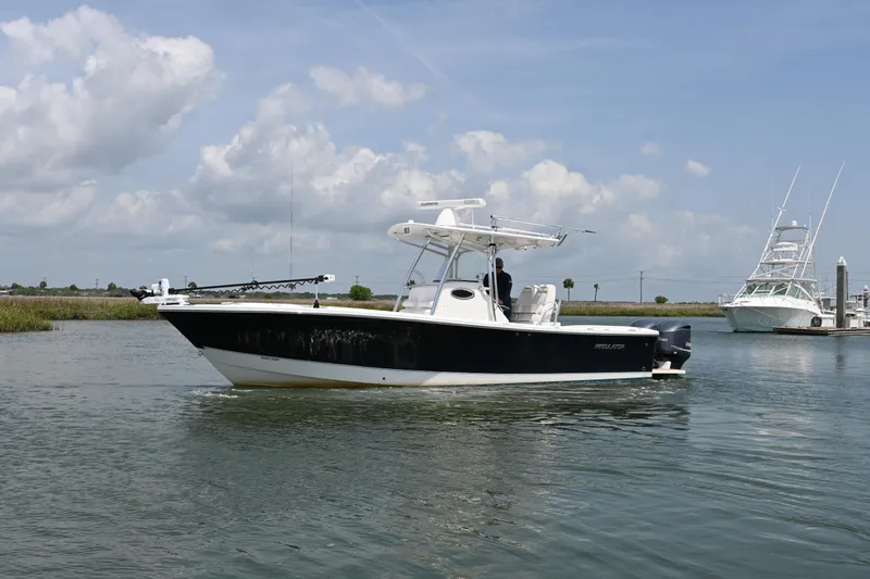 Slide: The Image of 2012 Regulator 28 Forward Seating boat on calm water under a cloudy sky. - 0
