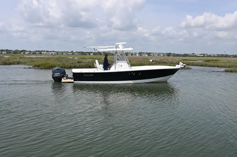 Slide: The Image of 2012 Regulator 28 Forward Seating boat cruising on calm water under cloudy skies. - 1