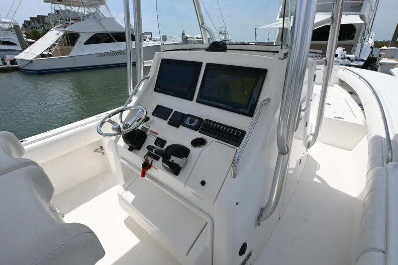 Slide: The Image of 2012 Regulator 28 Forward Seating boat cockpit with dual screens and steering wheel. - 12