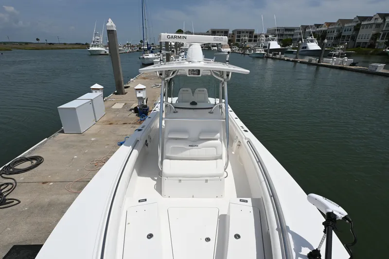 Slide: The Image of 2012 Regulator 28 Forward Seating boat docked at marina, featuring spacious deck and modern design. - 14