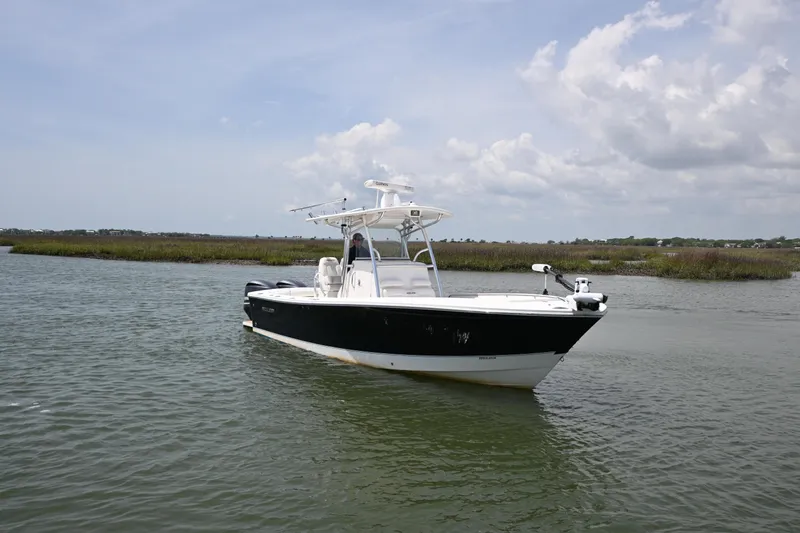 Slide: The Image of 2012 Regulator 28 Forward Seating boat on calm water under cloudy sky. - 3