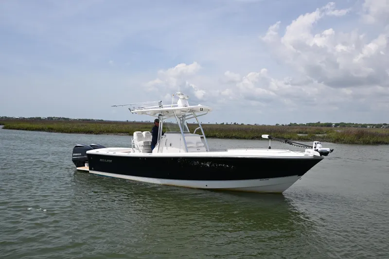 Slide: The Image of 2012 Regulator 28 Forward Seating boat on calm water under a cloudy sky. - 4