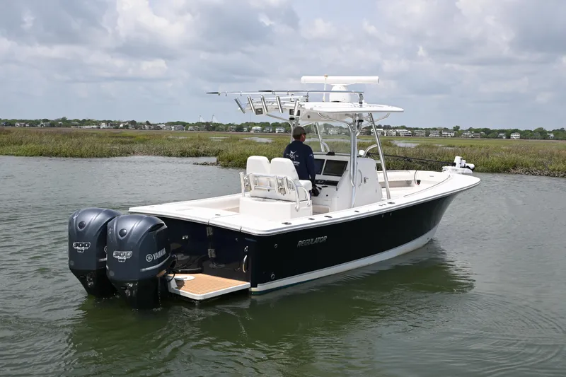 Slide: The Image of 2012 Regulator 28 Forward Seating boat with dual Yamaha engines on calm water. - 5