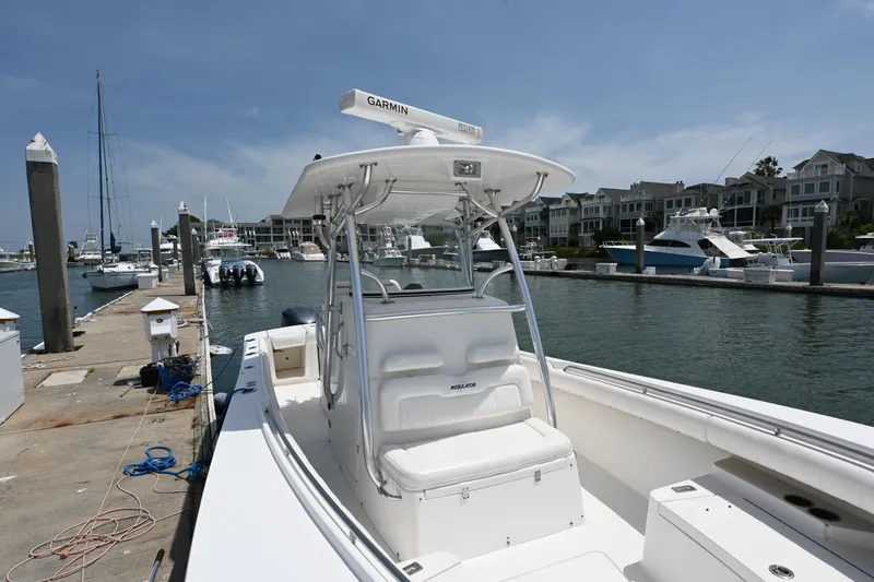 Slide: The Image of 2012 Regulator 28 Forward Seating boat docked at marina with waterfront homes in background. - 7