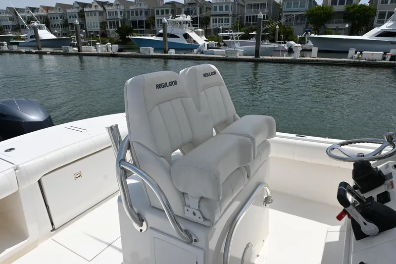 Slide: The Image of 2012 Regulator 28 Forward Seating boat with dual helm seats, docked in a marina. - 8