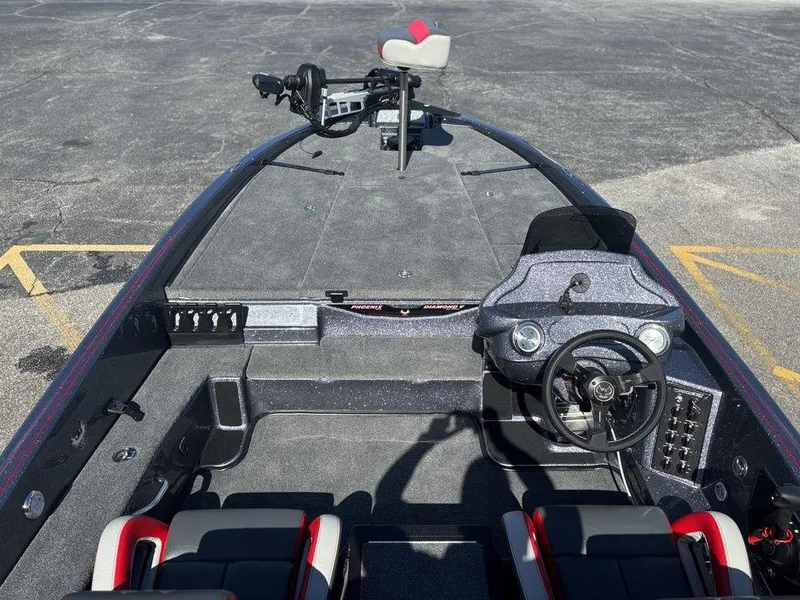 Slide: The Image of 2025 Phoenix 920 Elite boat interior with steering wheel and seating, parked on asphalt. - 12