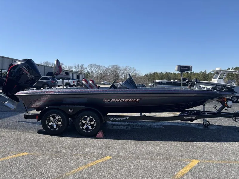 Slide: The Image of 2025 Phoenix 920 Elite boat on trailer, parked outdoors under clear blue sky. - 6