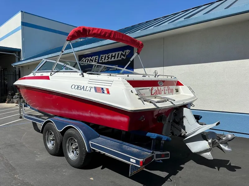 Slide: The Image of 1991 Cobalt Condurre 222 boat on trailer, red and white design, parked outside a building. - 9