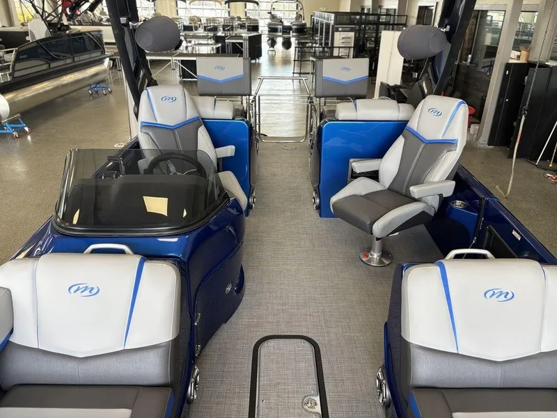 Slide: The Image of 2024 Manitou 25 XT SRS SHP boat interior with blue and gray seating, modern design. - 12
