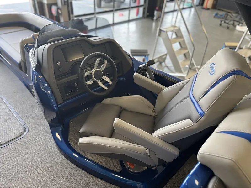 Slide: The Image of 2024 Manitou 25 XT SRS SHP boat interior with modern steering and comfortable seating. - 14