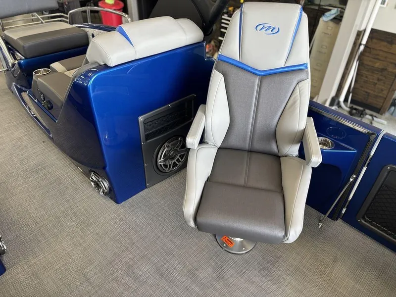 Slide: The Image of 2024 Manitou 25 XT SRS SHP boat interior with blue and gray seating. - 16