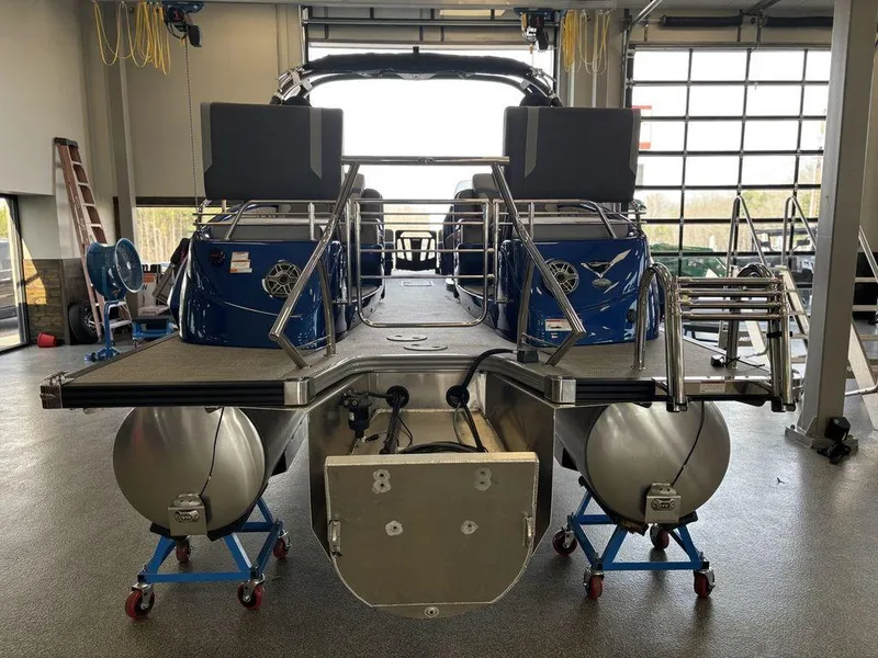 Slide: The Image of 2024 Manitou 25 XT SRS SHP pontoon boat in a garage setting. - 5