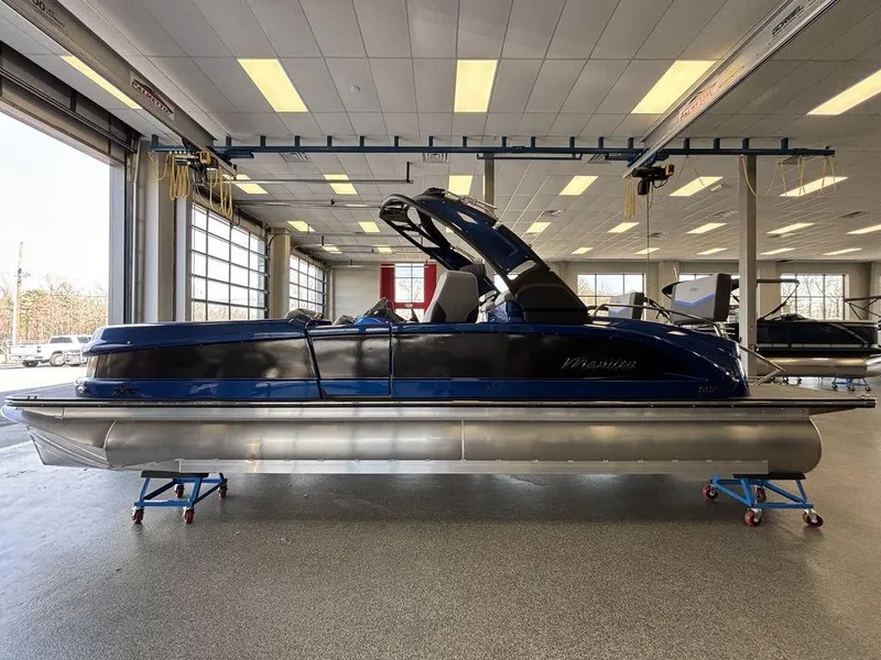 Slide: The Image of 2024 Manitou 25 XT SRS SHP pontoon boat in a showroom setting. - 6