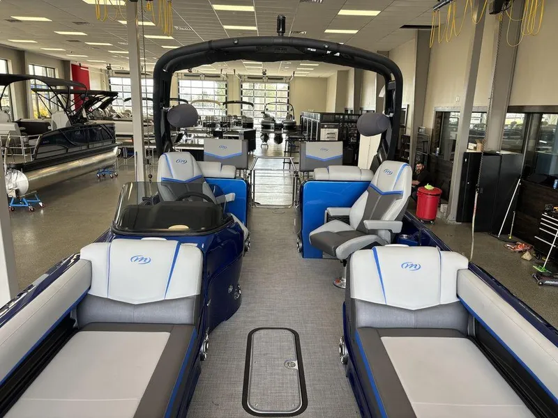Slide: The Image of 2024 Manitou 25 XT SRS SHP pontoon boat interior in showroom setting. - 8
