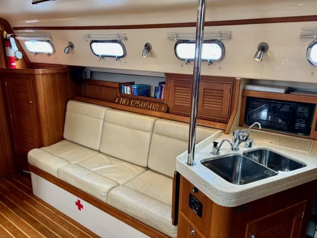 Slide: The Image of Interior of 2008 Island Packet 370 sailboat with sofa, sink, and portholes. - 1