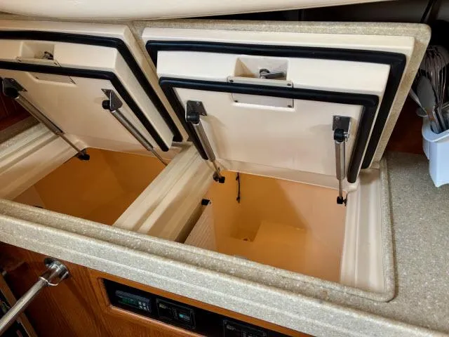 Slide: The Image of Open storage compartments in 2008 Island Packet 370 yacht galley. - 11