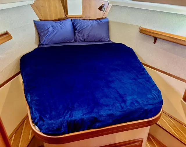 Slide: The Image of Cozy cabin bed in 2008 Island Packet 370 sailboat with blue bedding. - 13