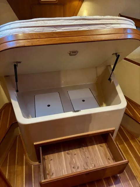 Slide: The Image of Interior storage compartment in a 2008 Island Packet 370 sailboat with wooden flooring. - 14