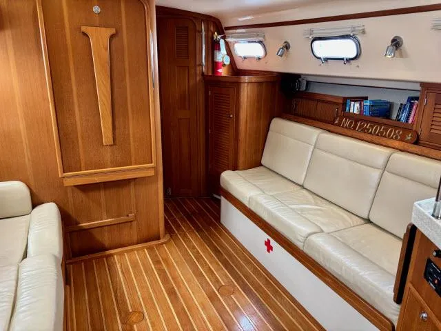 Slide: The Image of Interior of 2008 Island Packet 370 sailboat with wooden flooring and beige seating. - 2