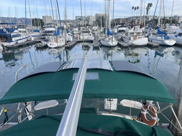 Slide: The Image of 2008 Island Packet 370 sailboat docked in a marina with green canopy. - 25