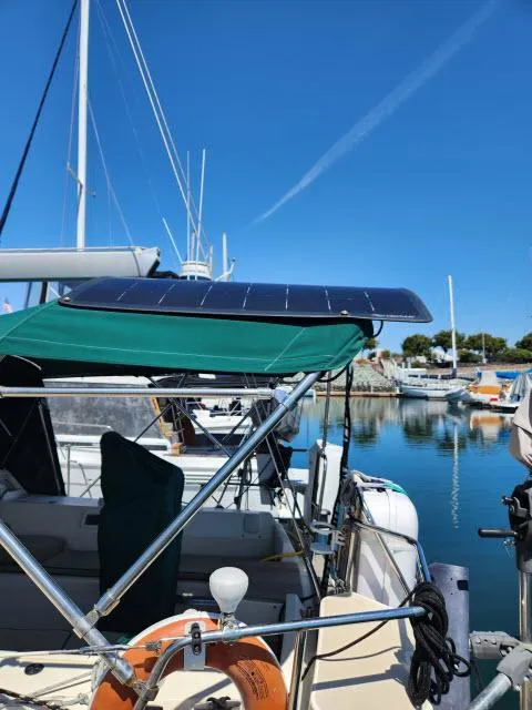 Slide: The Image of 2008 Island Packet 370 sailboat with solar panel, docked in a marina under clear blue skies. - 26