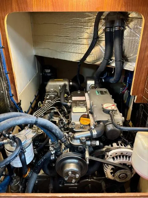 Slide: The Image of Engine compartment of a 2008 Island Packet 370 sailboat, showcasing mechanical components and wiring. - 29