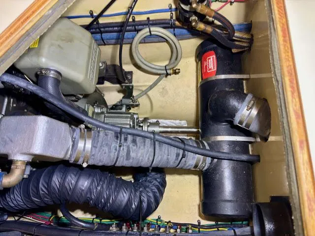 Slide: The Image of Engine compartment of a 2008 Island Packet 370 sailboat, showing mechanical components and hoses. - 30