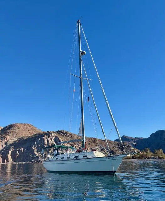 Slide: The Image of 2008 Island Packet 370 sailboat on calm water with mountainous backdrop. - 43