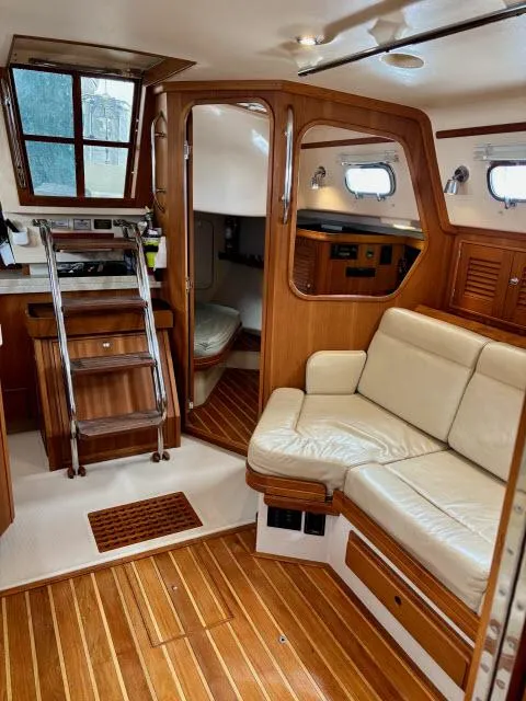 Slide: The Image of Interior of 2008 Island Packet 370 sailboat with wooden flooring and cream seating. - 5