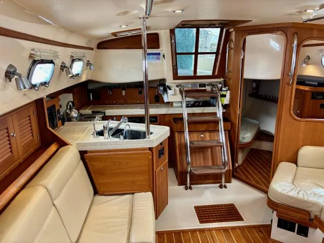 Slide: The Image of Interior of 2008 Island Packet 370 sailboat with wood finish and cozy seating area. - 7
