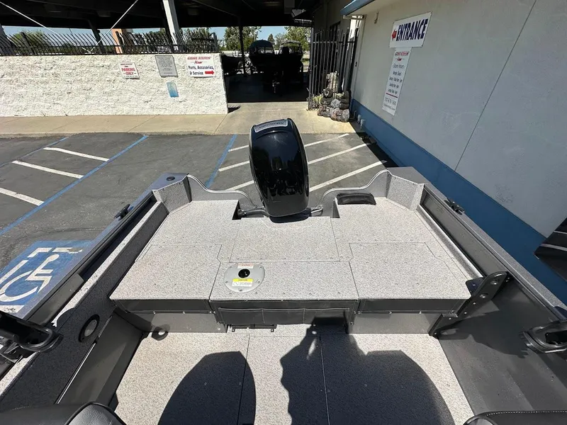 Slide: The Image of 2017 Crestliner 1600 Vision boat interior with motor, parked in a lot. - 13