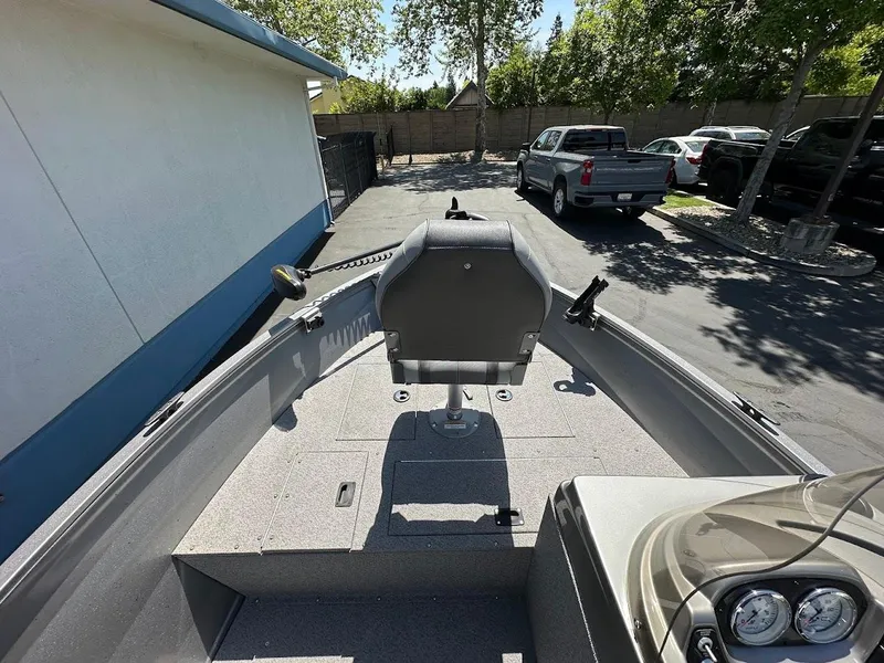 Slide: The Image of 2017 Crestliner 1600 Vision boat interior with seating and control panel, parked outdoors. - 22