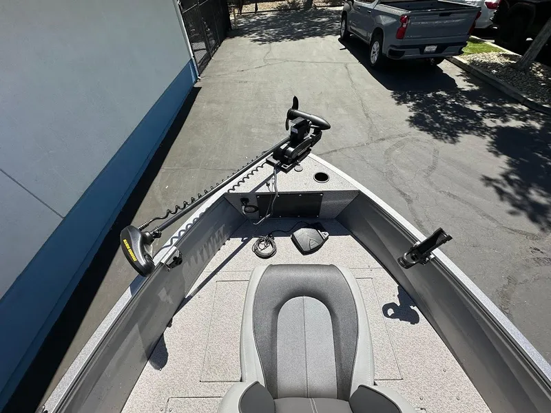 Slide: The Image of 2017 Crestliner 1600 Vision boat with trolling motor and seating, parked on driveway. - 23