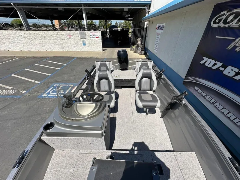 Slide: The Image of 2017 Crestliner 1600 Vision boat interior with seating and steering console in a parking area. - 28