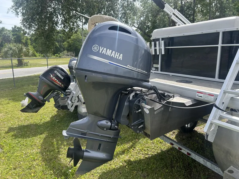 Slide: The Image of Outboard motors on a 2022 Sweetwater SW 1886 c pontoon boat, parked on grass. - 10
