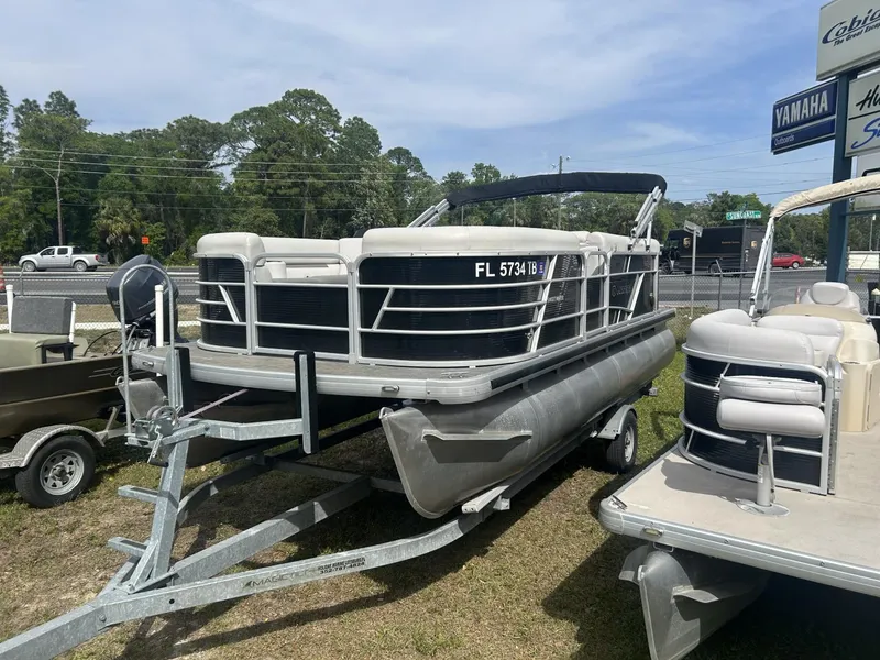 Slide: The Image of 2022 Sweetwater SW 1886 c pontoon boat on trailer, parked outdoors. - 6