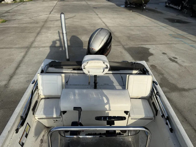 Slide: The Image of 2016 Ranger RP 190 boat interior with seating and motor, parked on concrete. - 7