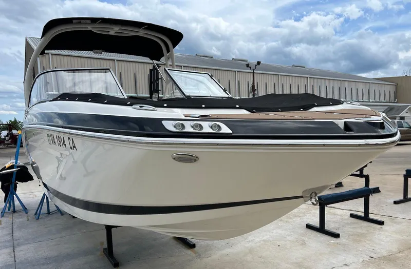 Slide: The Image of 2016 Chaparral 250 Suncoast boat on display, white hull, docked outdoors under cloudy sky. - 1