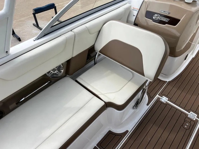 Slide: The Image of 2016 Chaparral 250 Suncoast boat interior with brown and white seating and wood-style flooring. - 10