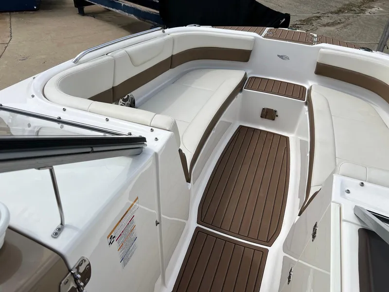 Slide: The Image of 2016 Chaparral 250 Suncoast boat interior with white and brown seating and flooring. - 11
