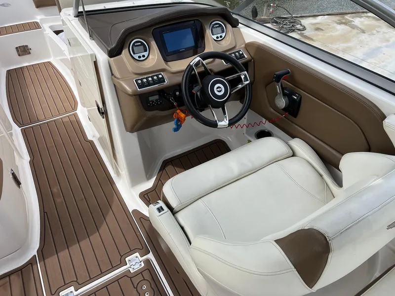 Slide: The Image of 2016 Chaparral 250 Suncoast boat interior with steering wheel and dashboard controls. - 13