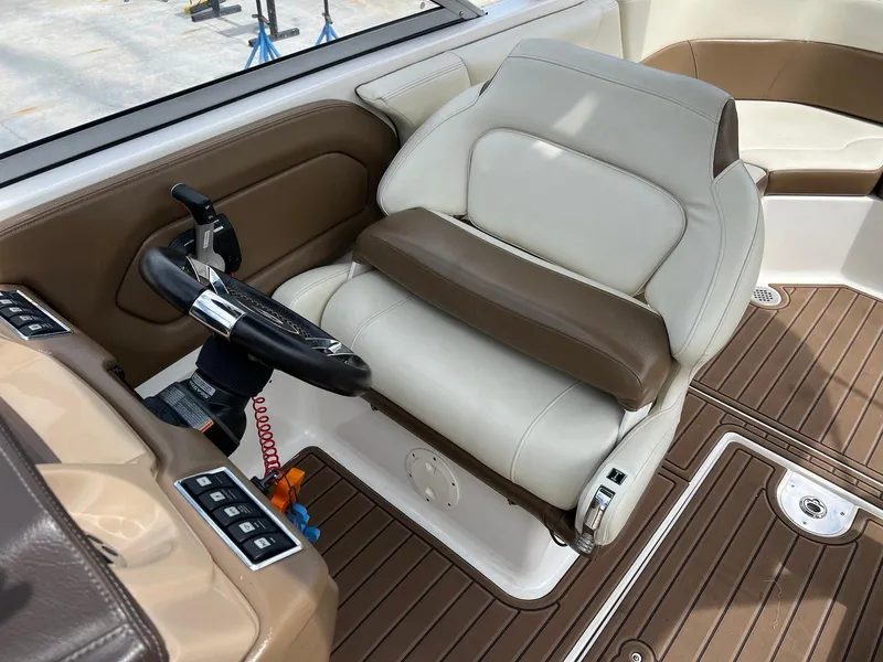 Slide: The Image of 2016 Chaparral 250 Suncoast boat interior with steering wheel and cushioned seating. - 14