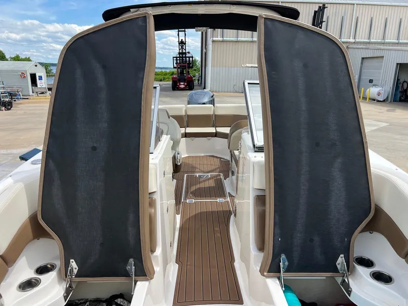 Slide: The Image of 2016 Chaparral 250 Suncoast boat interior with open canopy and wooden deck. - 15