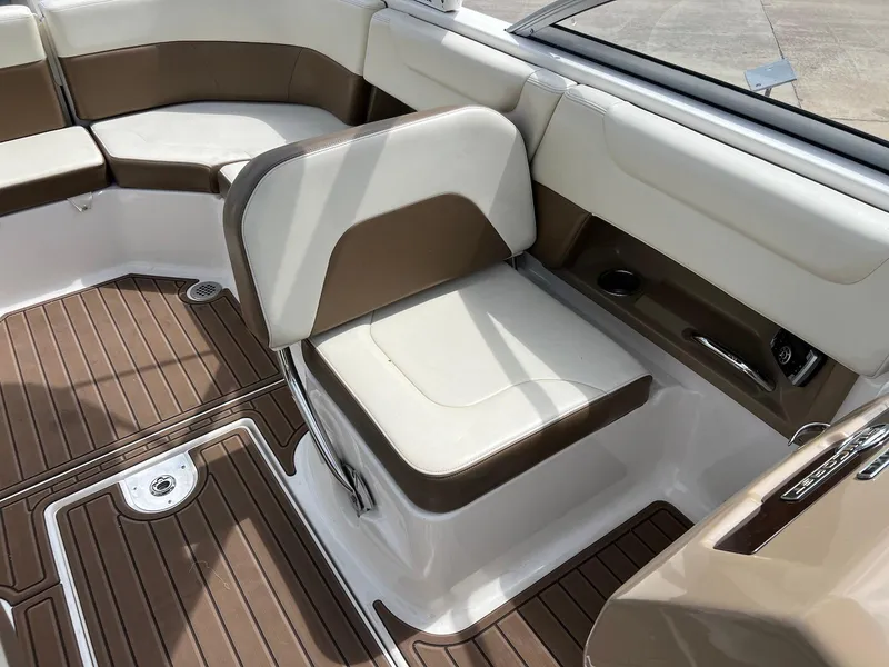 Slide: The Image of 2016 Chaparral 250 Suncoast boat interior with brown and white seating and flooring. - 18