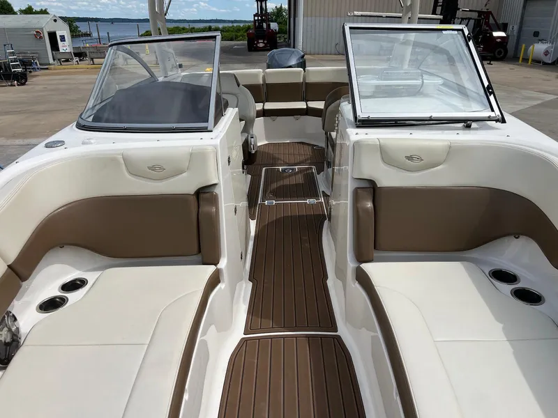 Slide: The Image of 2016 Chaparral 250 Suncoast boat interior with beige seating and wood-style flooring. - 6