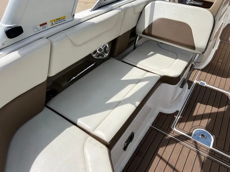 Slide: The Image of 2016 Chaparral 250 Suncoast boat interior with cushioned seating and wood-style flooring. - 7